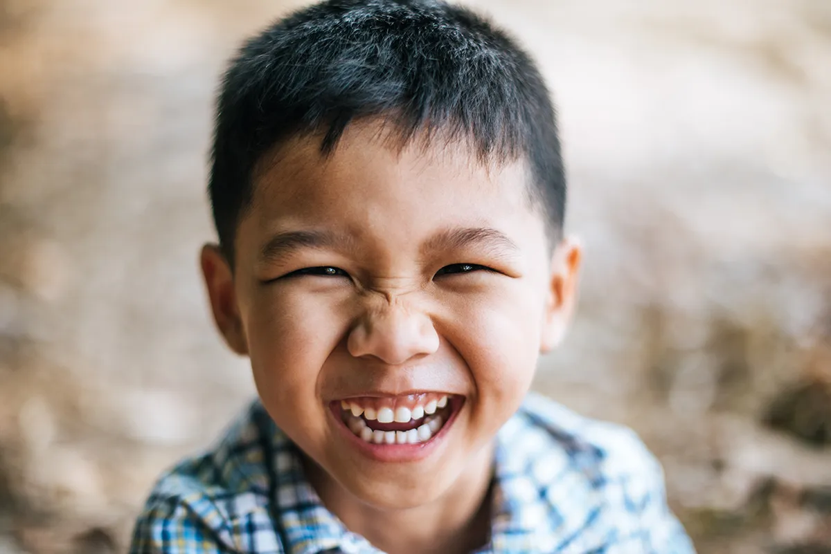 a young boy with a huge smile